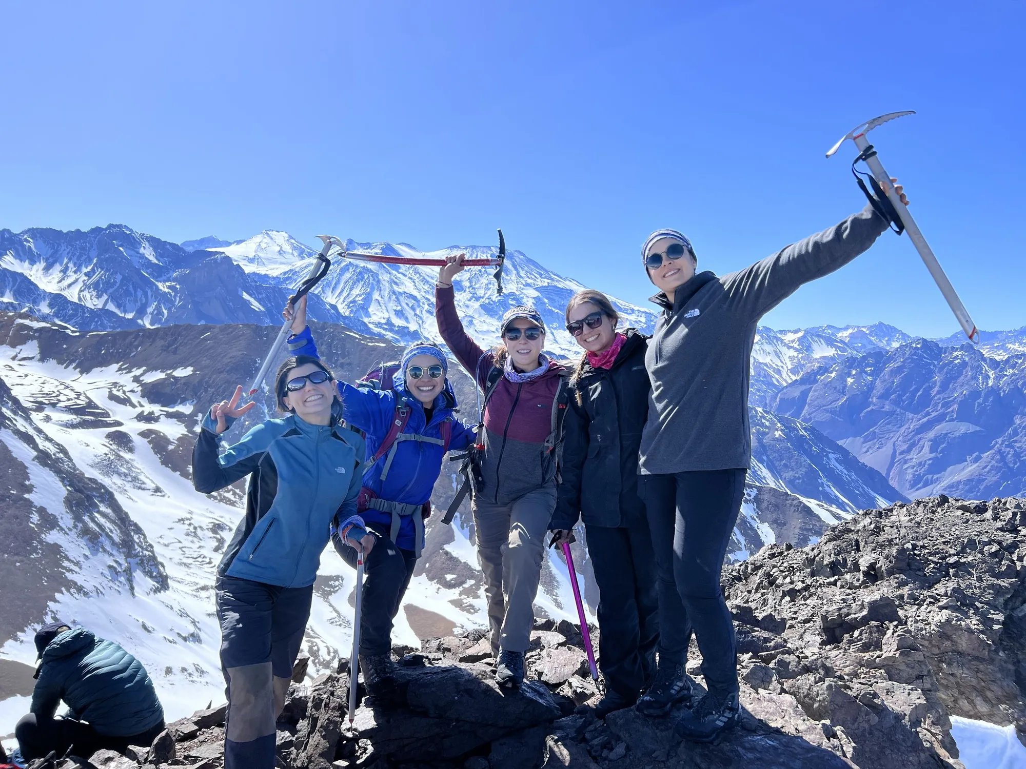 Donne in vetta con piccozza e montagne innevate
